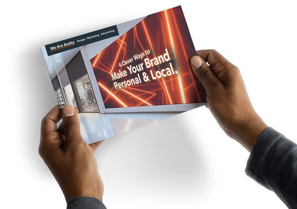 Hands holding a guide named 4 Clever Ways to Make Your Brand Personal & Local