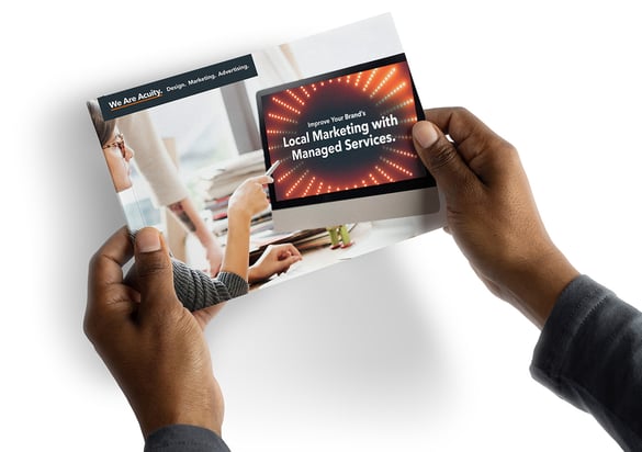 Hands holding a guide named Improve Your Brand's Local Marketing with Managed Services