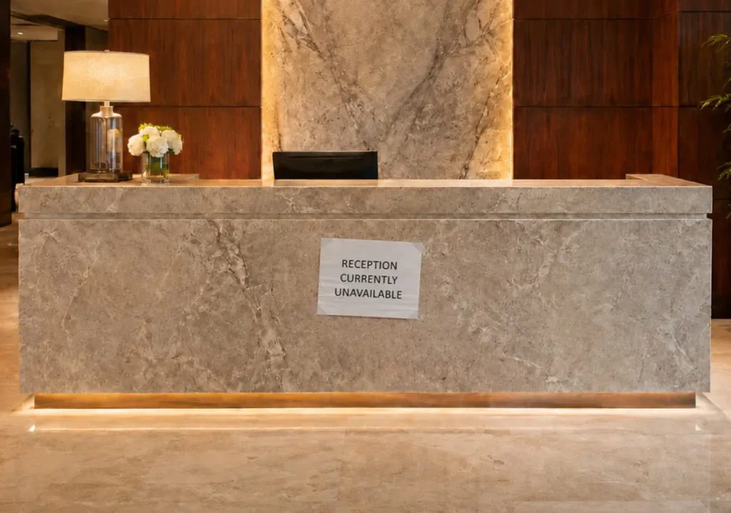 Unstaffed reception desk with temporary sign: Reception currently unavailable