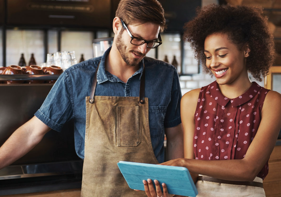 Tradesman and business woman looking over a laptop